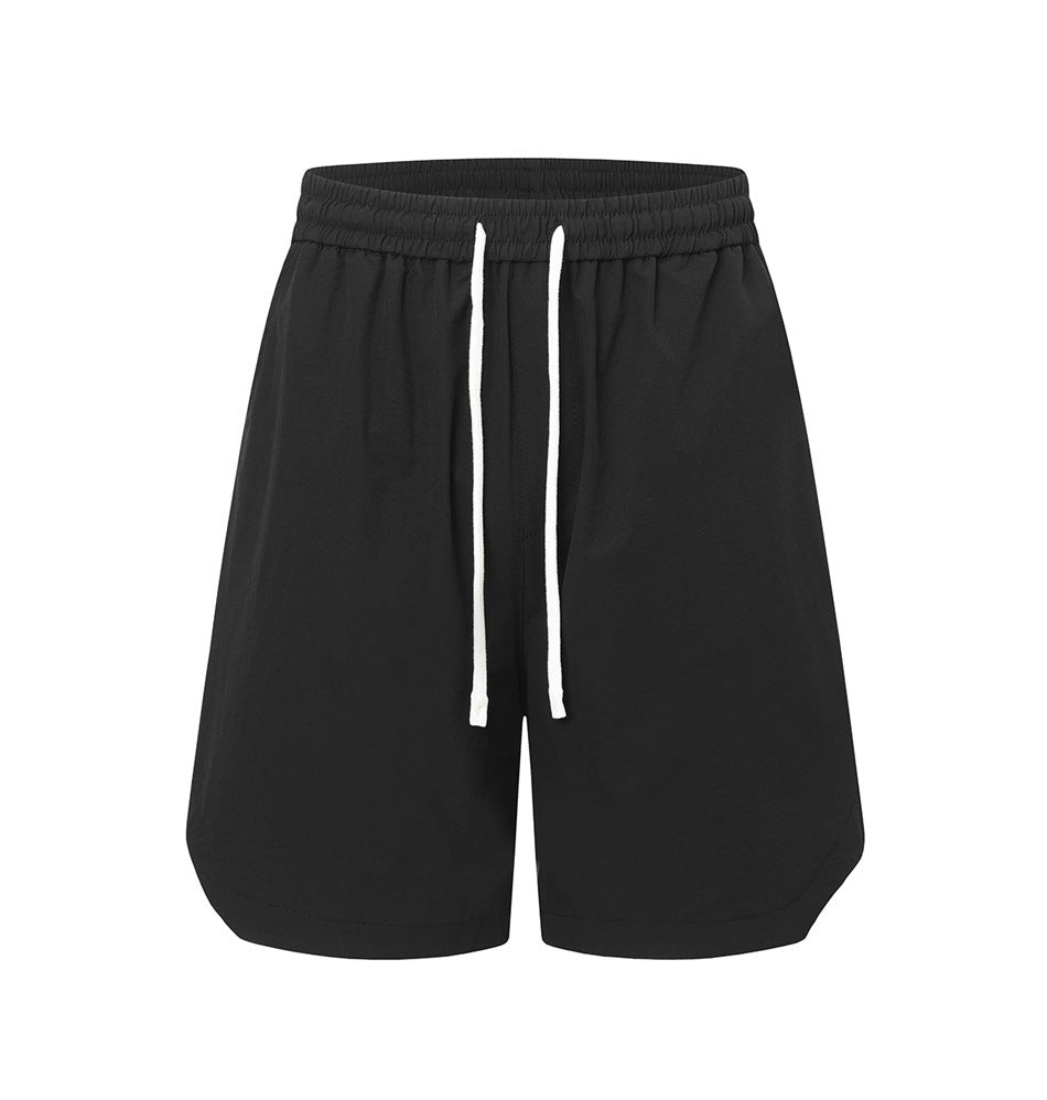 Black drawstring shorts with elastic waistband and curved side hems, front view on white background