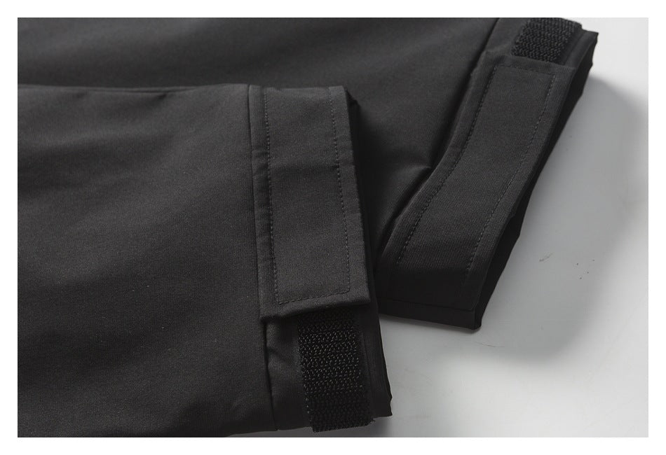 Close-up of black jacket cuffs with adjustable hook-and-loop tabs.