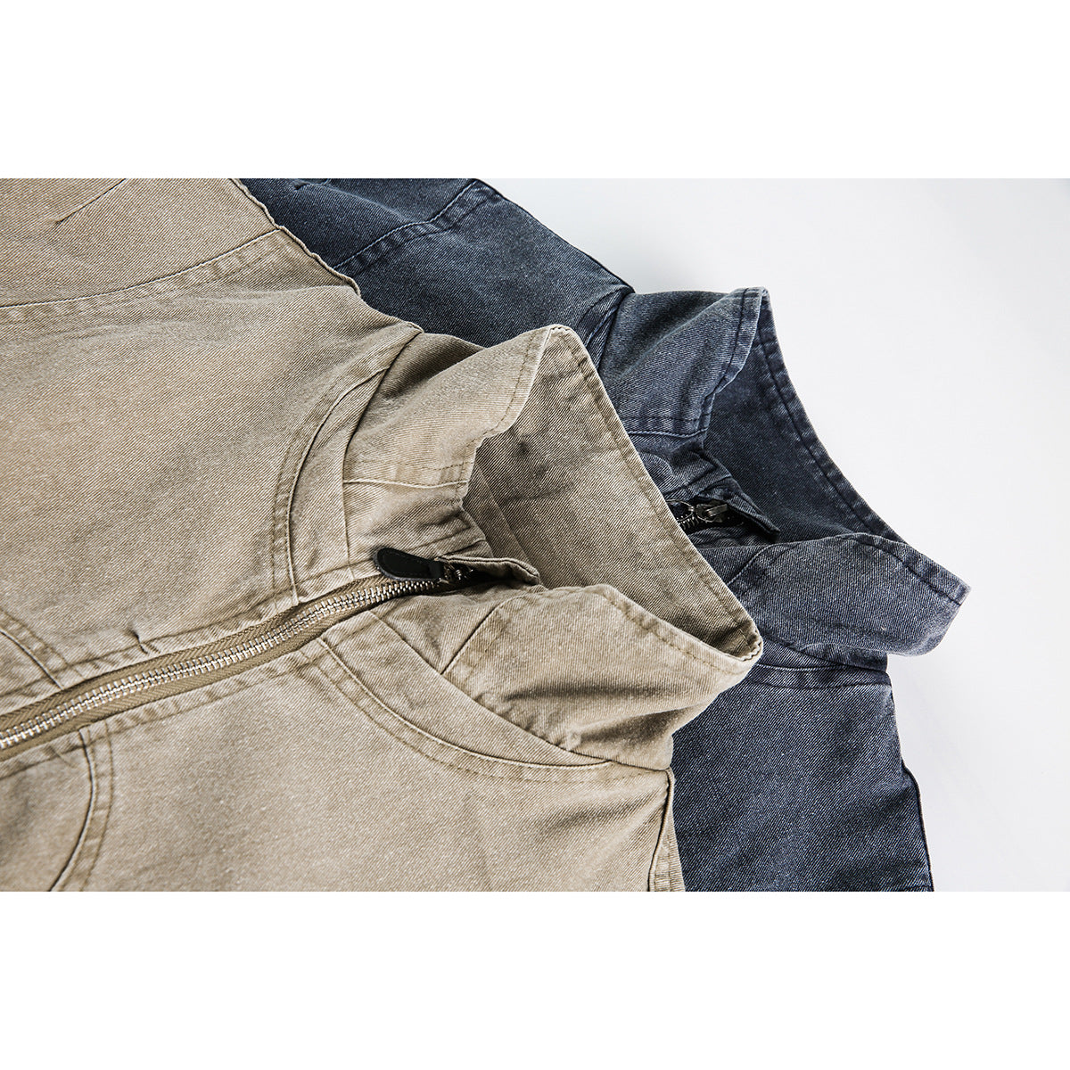 Close-up of tan and dark blue jackets showing their stand collars, seams, and front zippers.