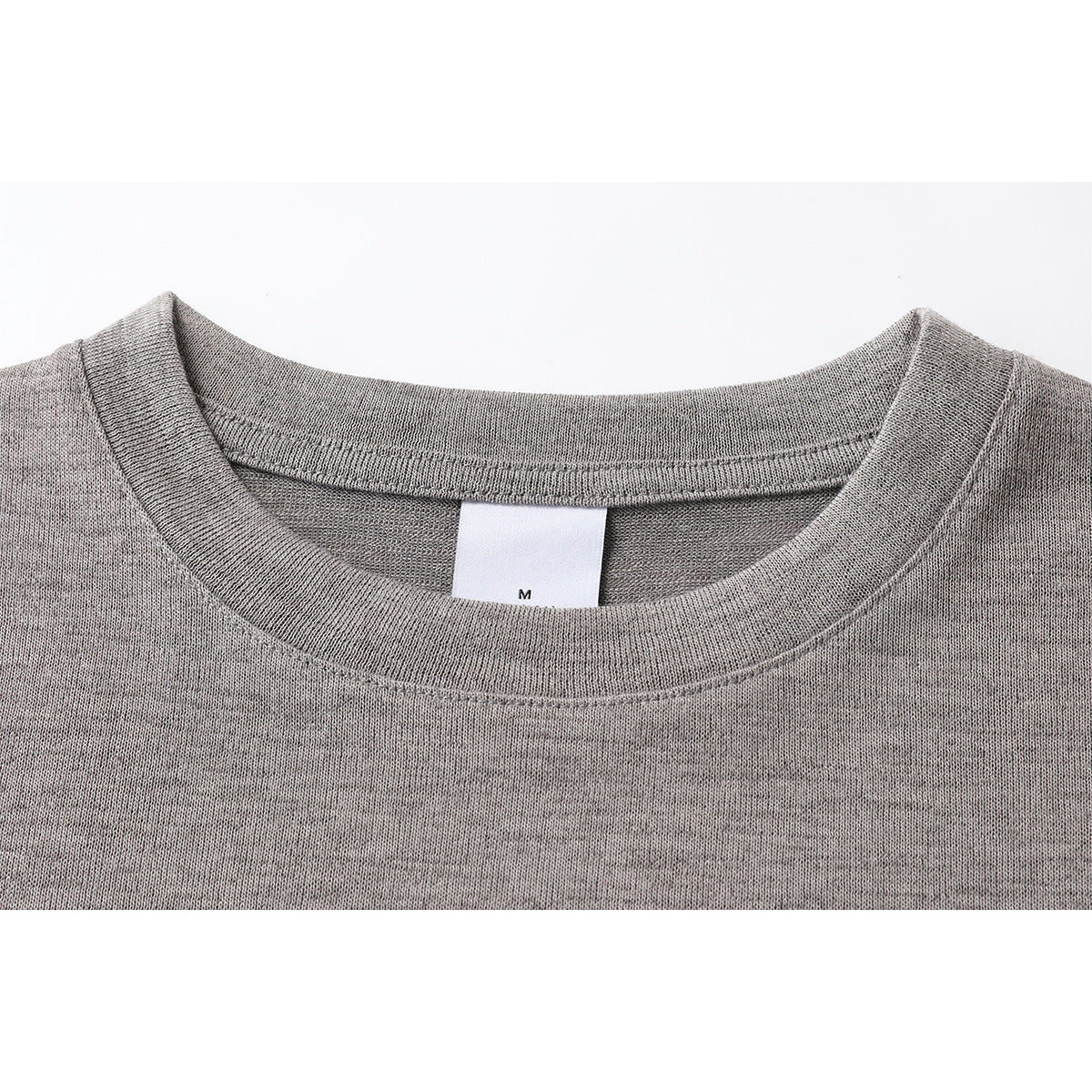 Close-up of a heather gray T-shirt crew neck and inner size label marked M.
