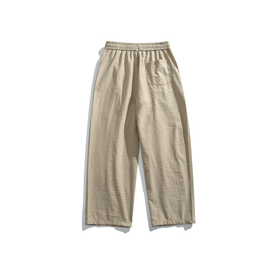 Back view of beige wide-leg pants with an elastic waist and a single patch pocket.