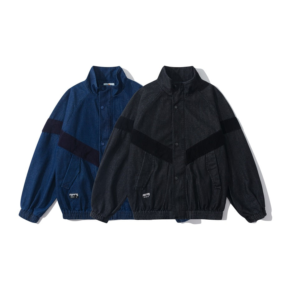 Two front-facing jackets, one blue and one charcoal, with stand collars, dark diagonal sleeve bands, and elastic hems.