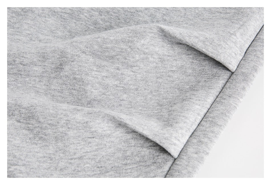 Close-up of light gray heather fabric with a folded seam and overlapping panel.