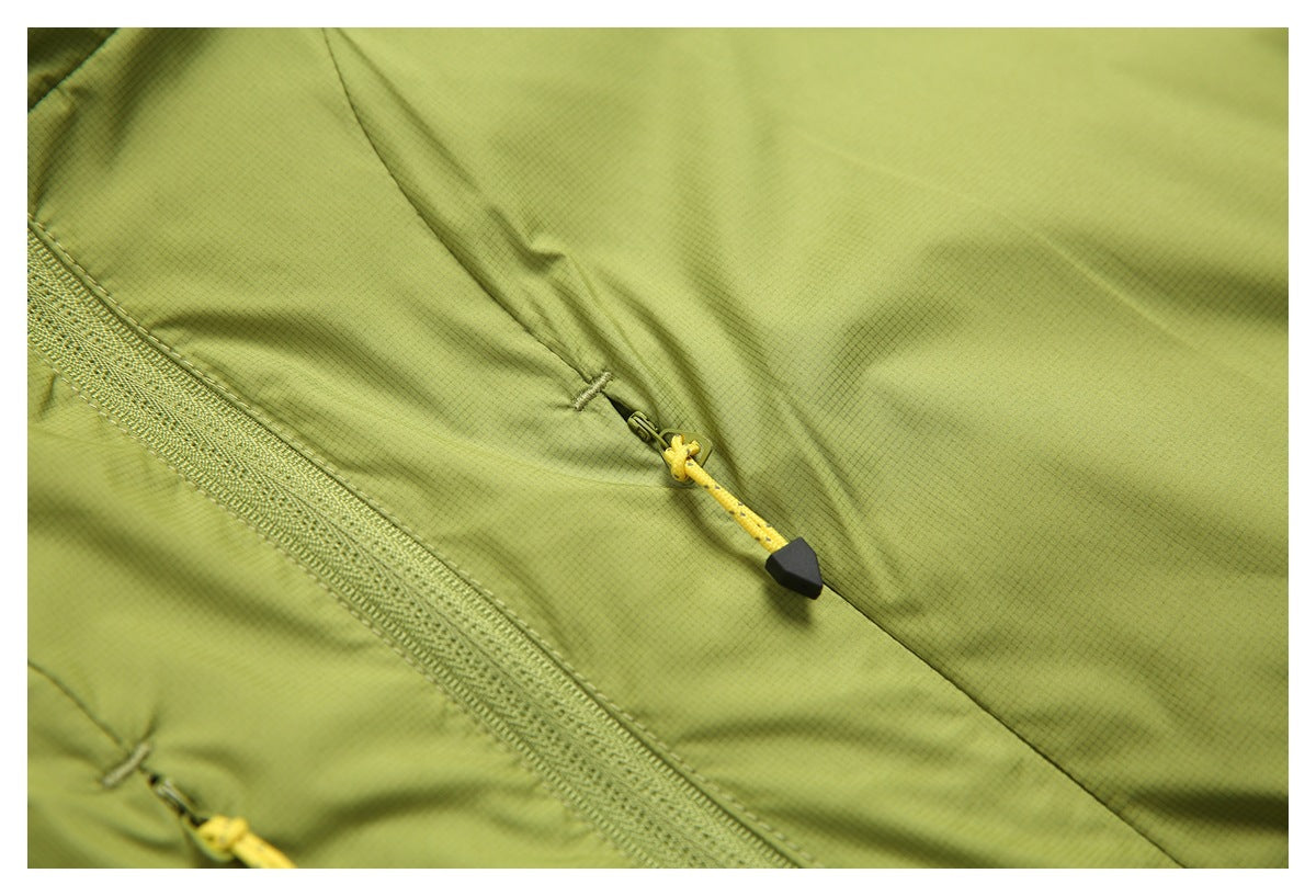 Close-up of an olive-green jacket with a diagonal zipper pocket and yellow cord pull.