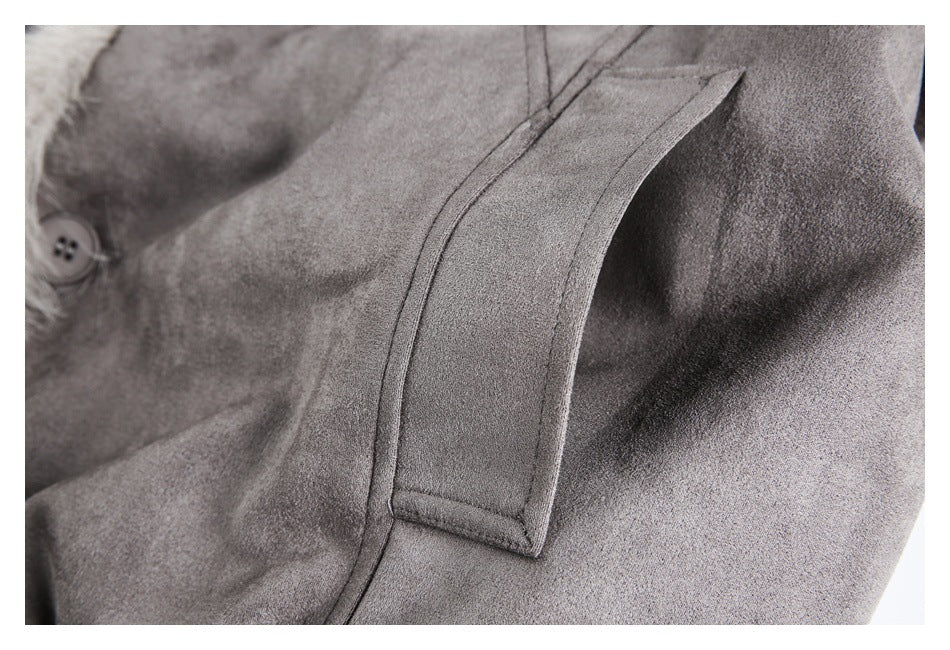 Close-up of a gray coat's stitched fabric tab and panel seams.
