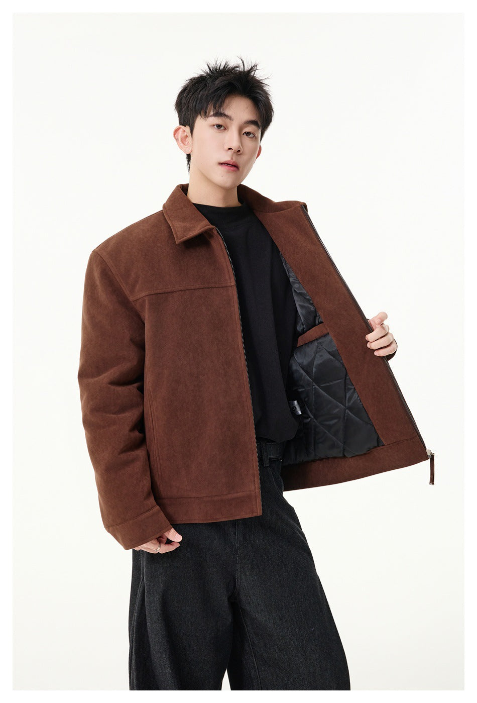 Model holds open a brown jacket to show its black quilted lining and interior pocket.
