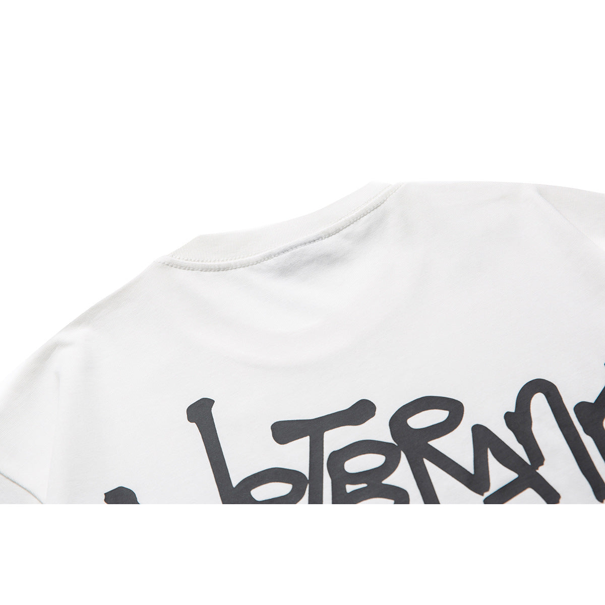 Close-up of the white T-shirt’s back with part of its large black graphic print.