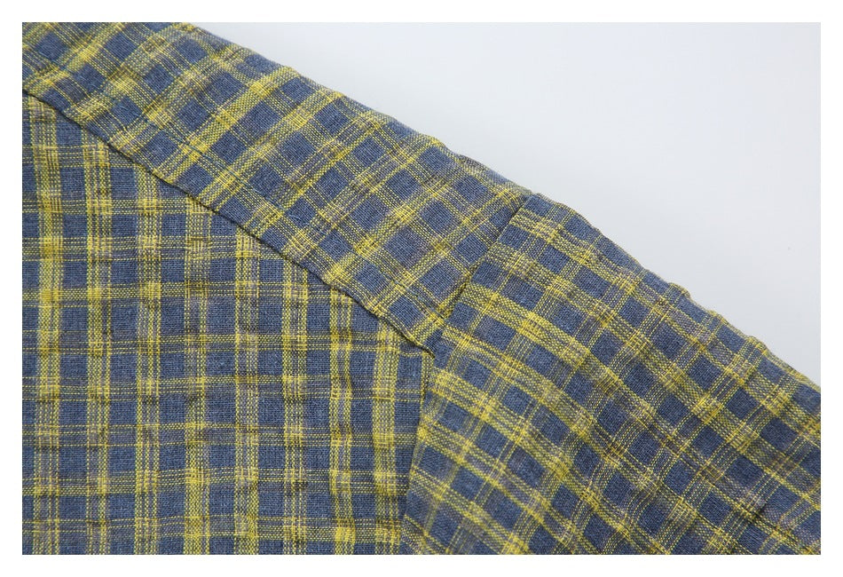 Close-up of the plaid shirt's shoulder seam and sleeve in blue-gray and mustard.