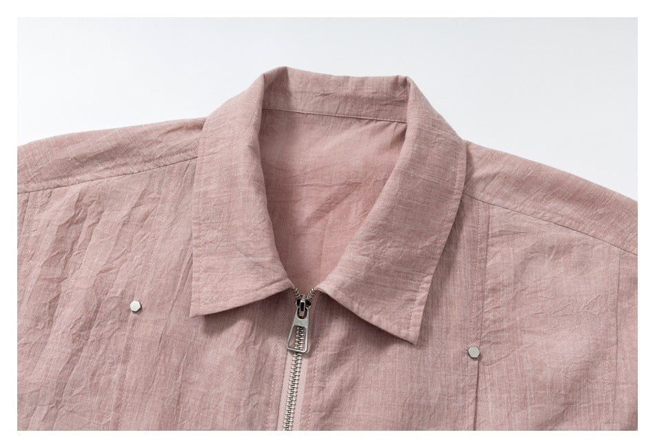Close-up of the pointed collar, central metal zipper and fasteners on a dusty rose shirt-jacket.