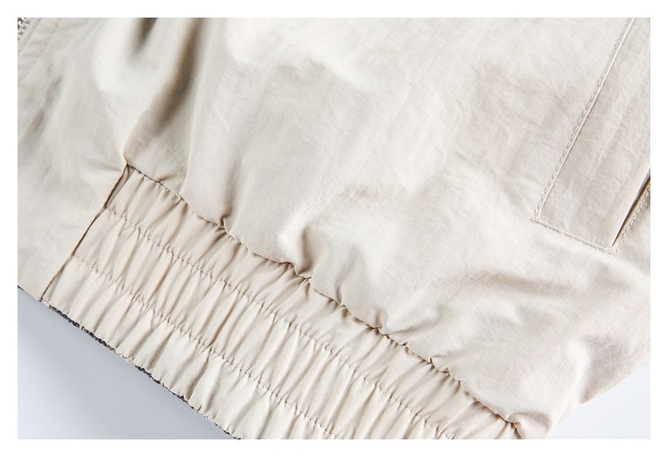 Close-up of the gathered elastic waistband and pocket seam on a light beige garment.