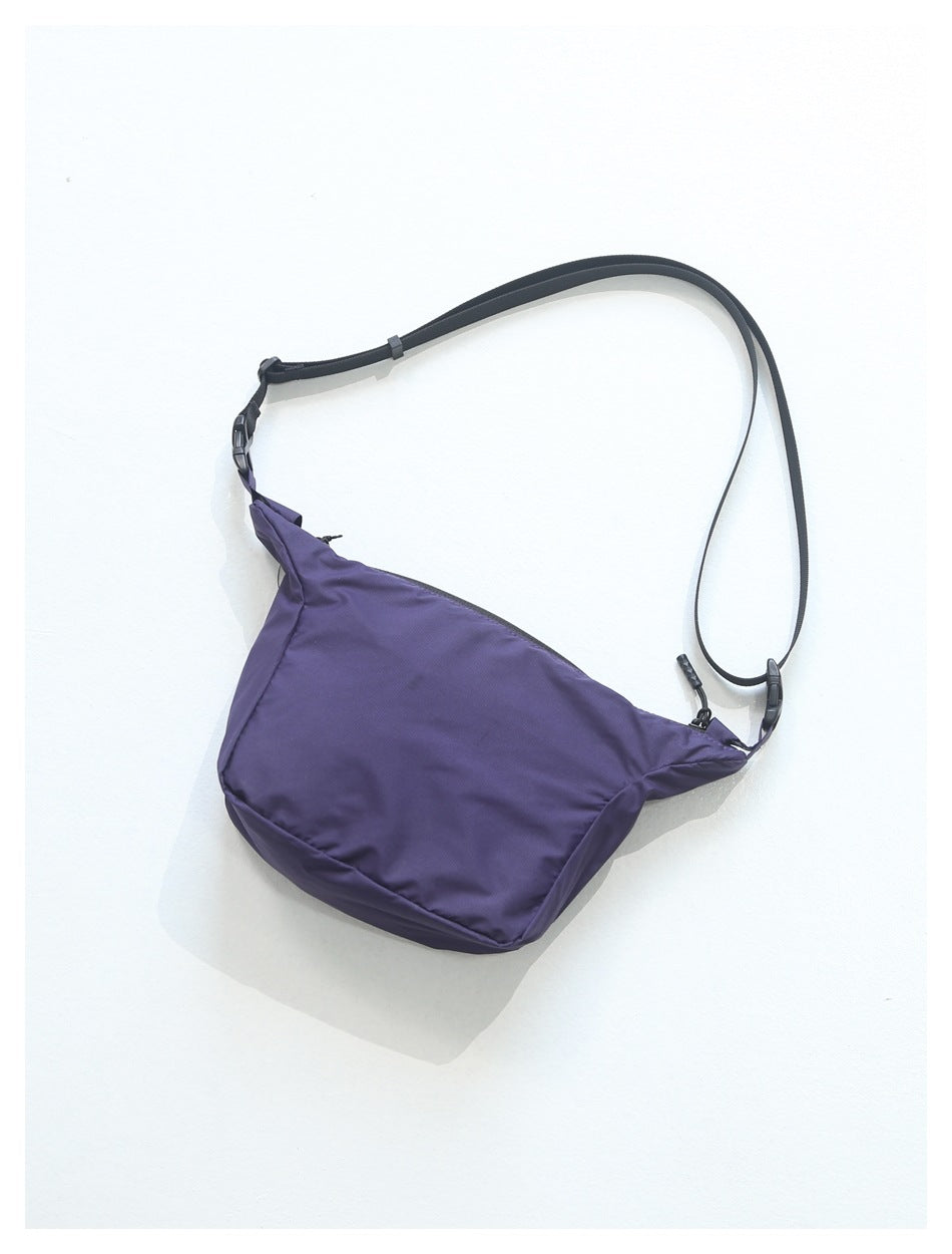 Purple crossbody bag with a wide black adjustable strap, shown against a white background.