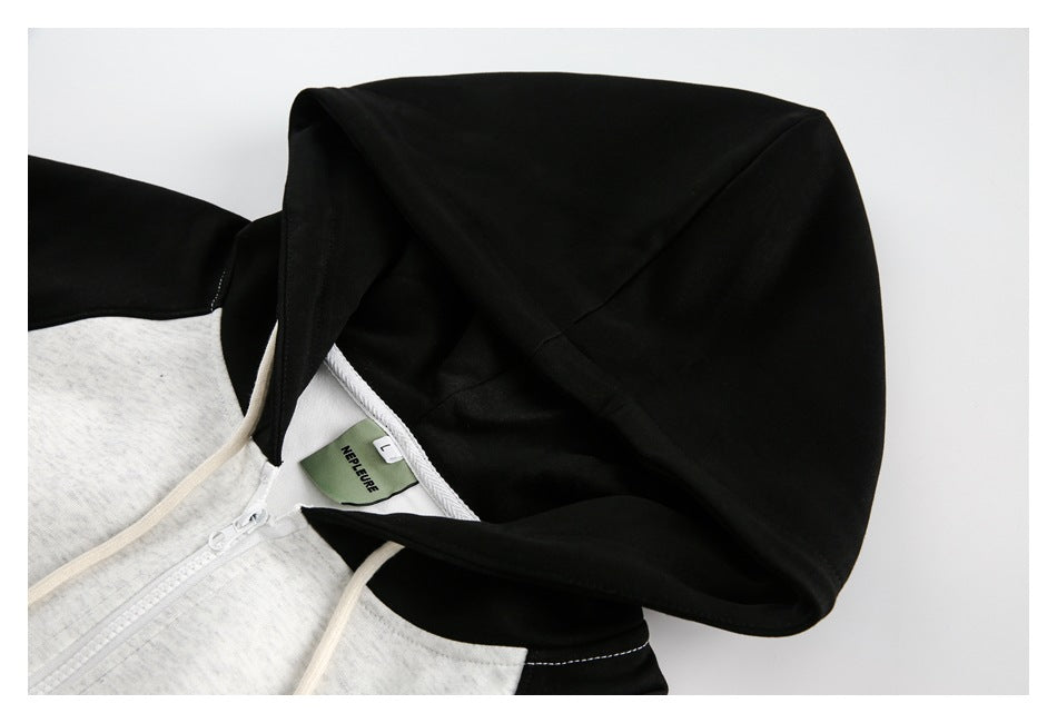 Close-up of a black hood on a light gray hoodie, with cream drawstrings and the neckline visible.