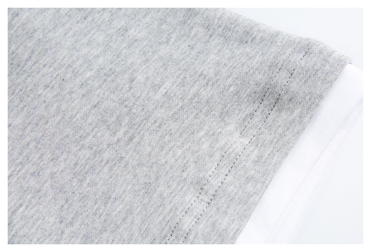 Close-up of a heather gray garment edge with parallel stitching and a white layer visible underneath.