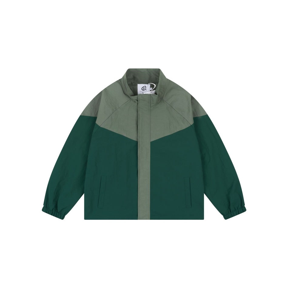 Green two-tone stand-collar jacket flat lay, front view, with chevron panel and elastic cuffs