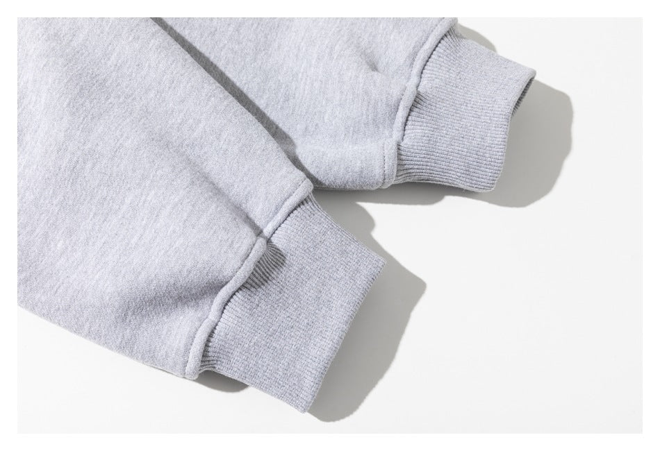 Close-up of two ribbed cuffs on a light gray sweatshirt against a white background.