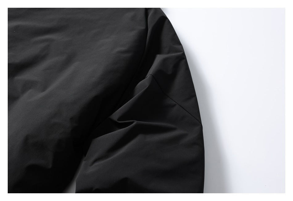 Close-up of a black jacket sleeve and stitched underarm seam.