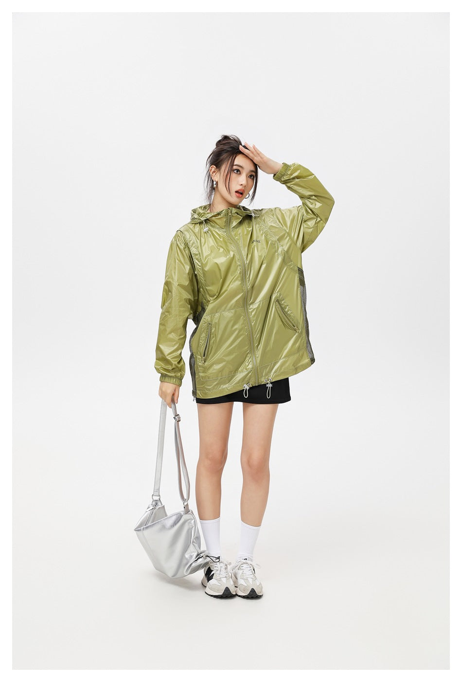 Model wearing a zipped olive hooded jacket with zip pockets and mesh side panels, shown from the front.
