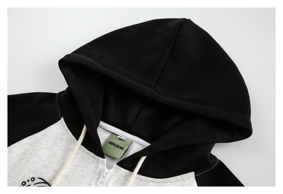 Close-up of the black hood and upper chest of a heather light-gray zip hoodie, with cream drawstrings.