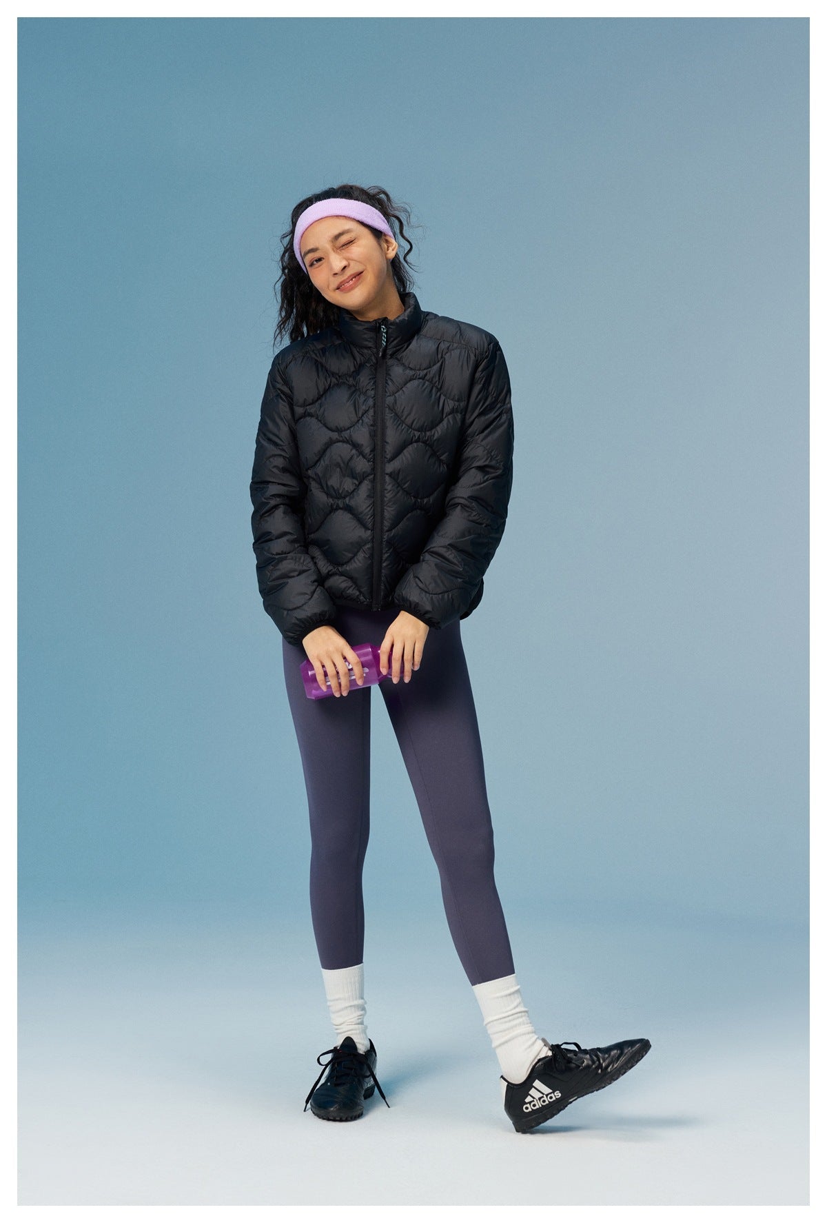 Model facing forward in a black quilted zip jacket with a stand collar.