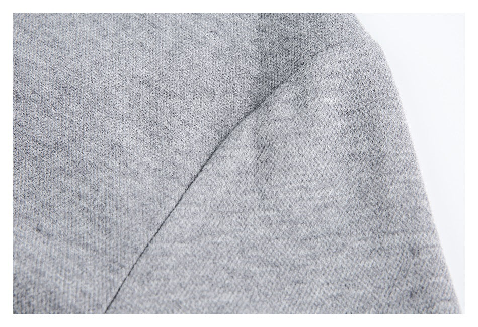 Close-up of a curved seam on the gray garment's textured fabric.