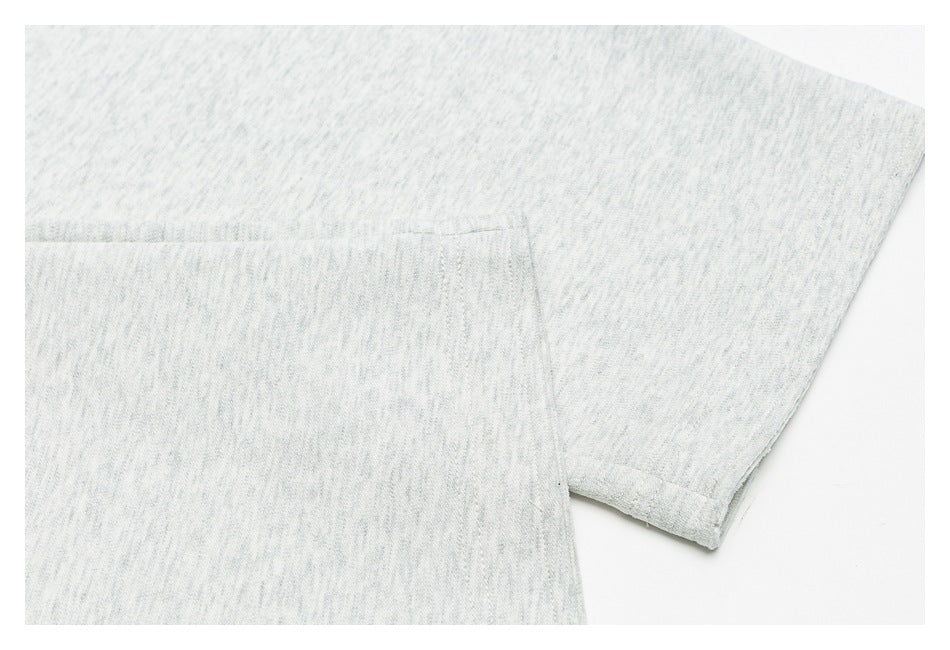 Close-up of light gray marl sweatpants showing a stitched leg hem and pocket edge.