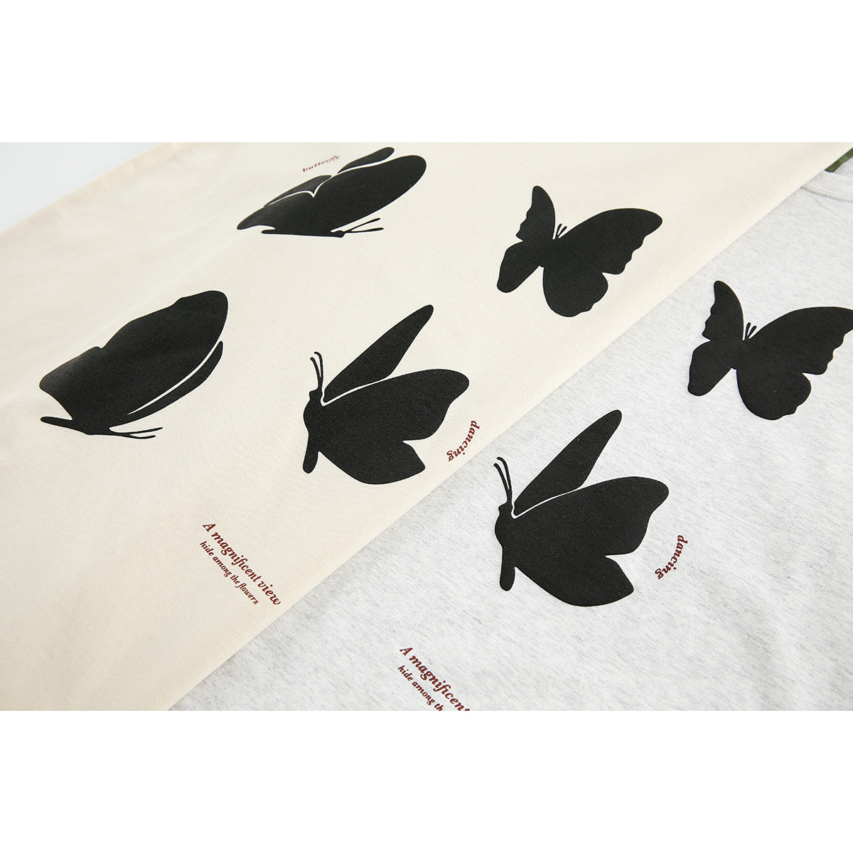 Close-up of cream and heather-gray T-shirts with black butterfly prints and small English text.