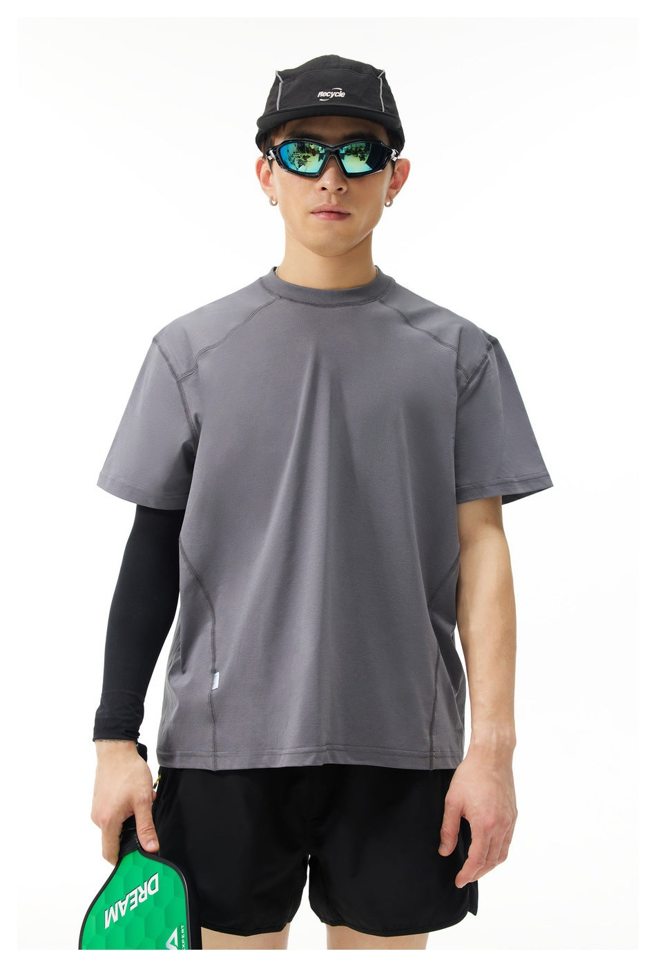 Model wearing a charcoal-gray short-sleeve crew-neck shirt with curved seam details, shown from the front.