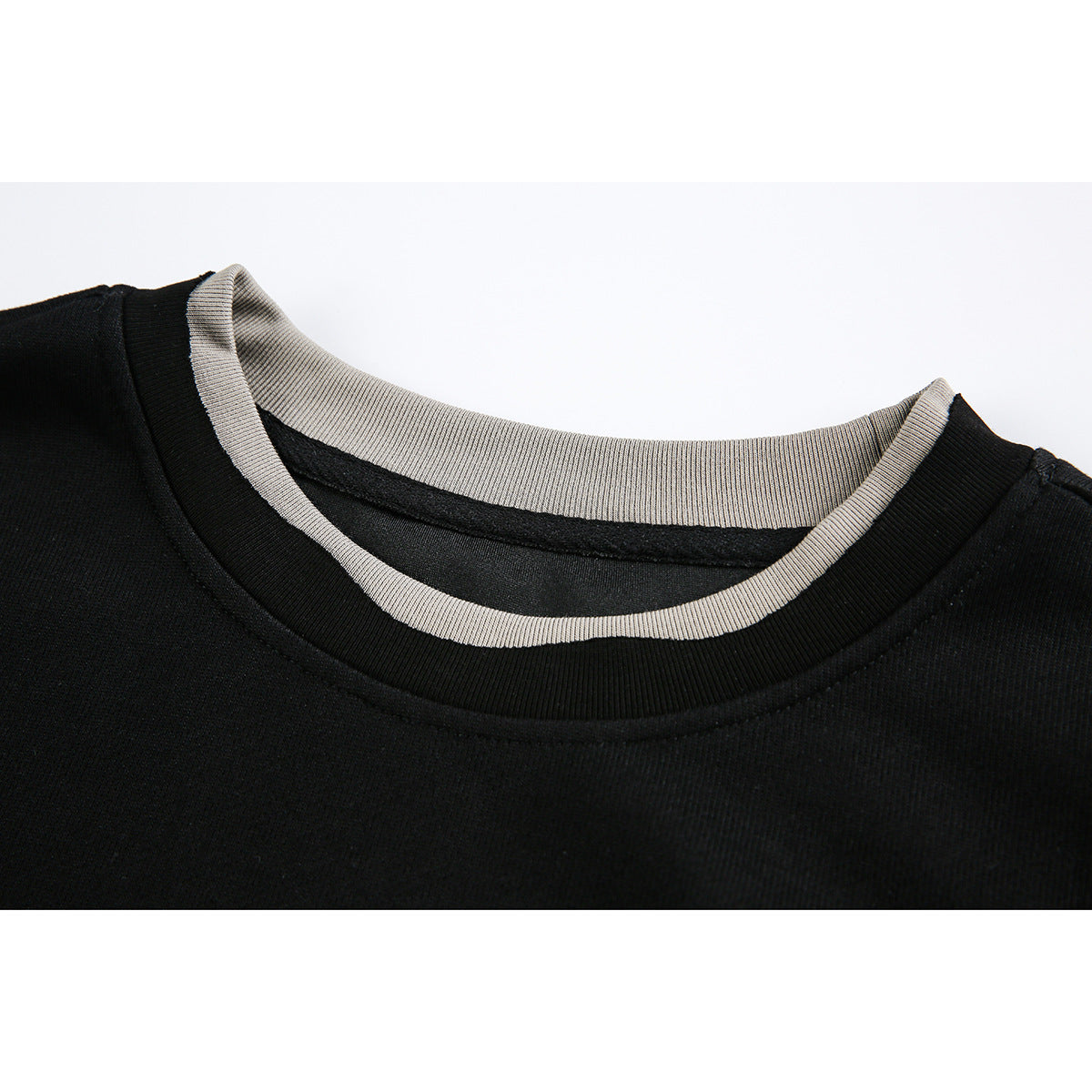 Close-up of a black crewneck sweatshirt with light gray ribbed inner collar trim.