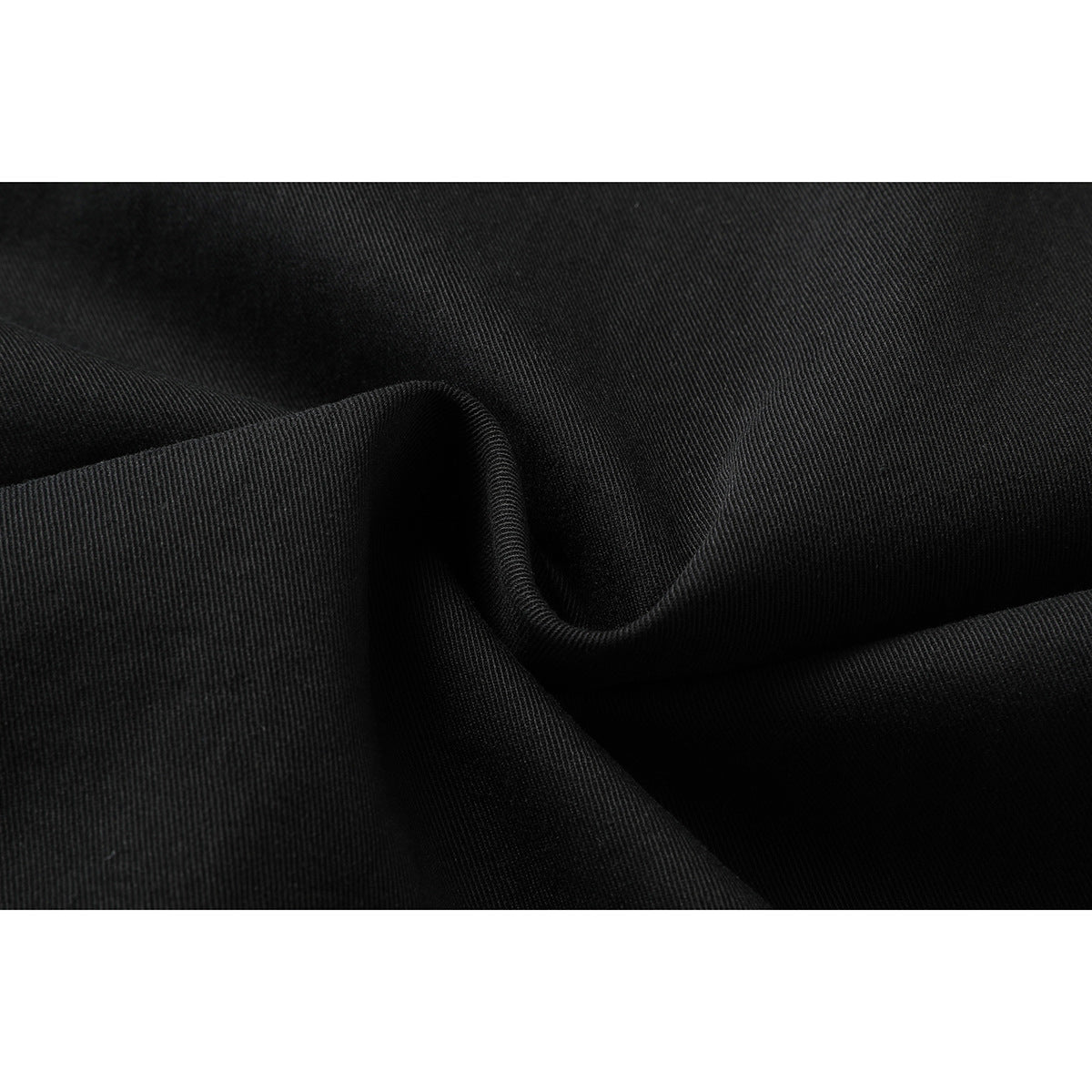Close-up of black fabric folded to show its fine diagonal texture.
