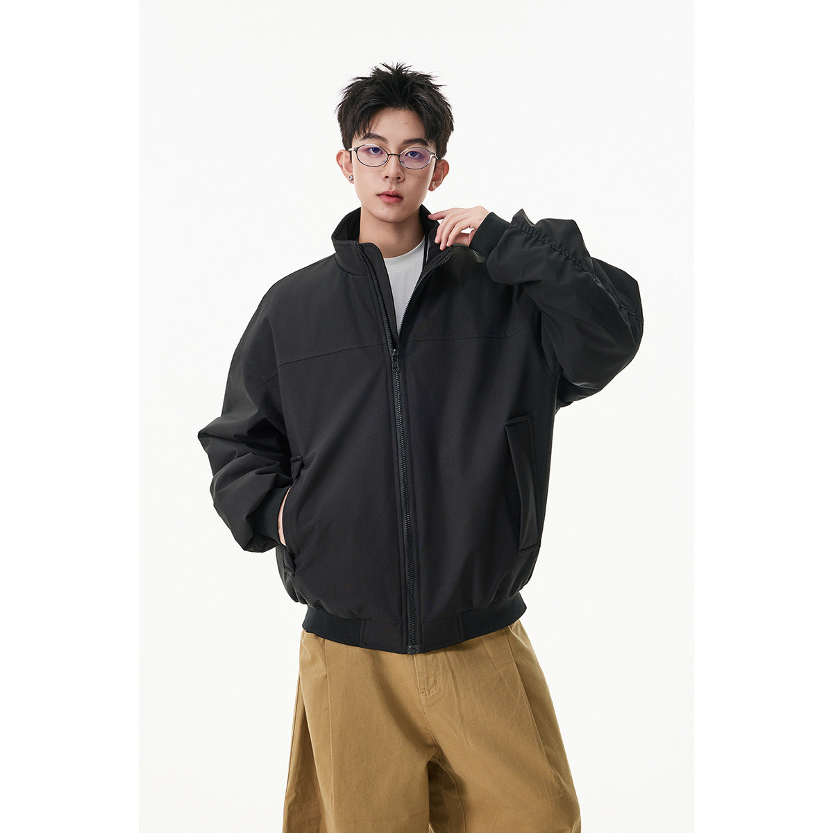 Model wearing a black oversized zip-up jacket with a stand collar and front pockets.