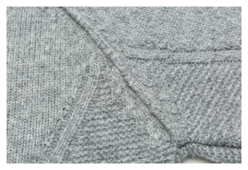Close-up of gray knit fabric with a diagonal seam and joining stitches.