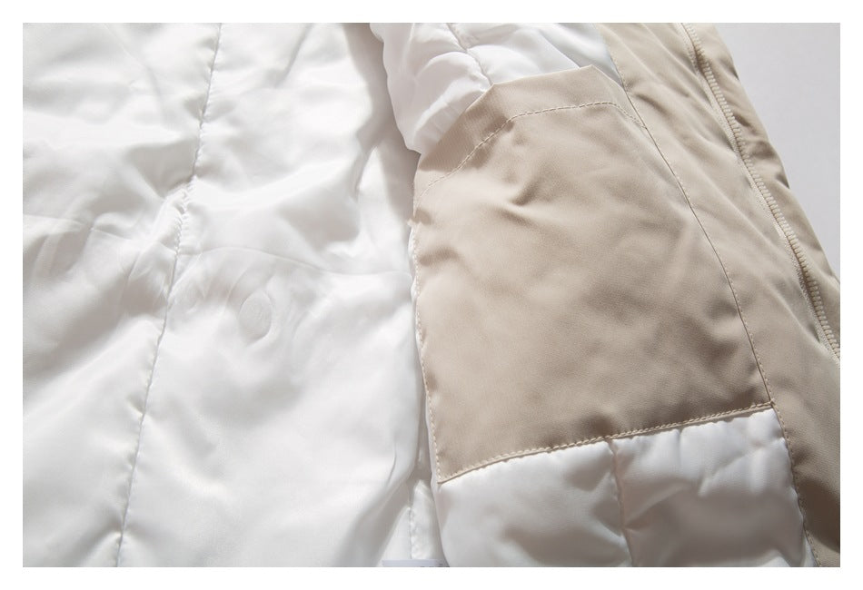 Close-up of a beige jacket's interior, showing a large pocket panel, white quilted lining, and zipper.