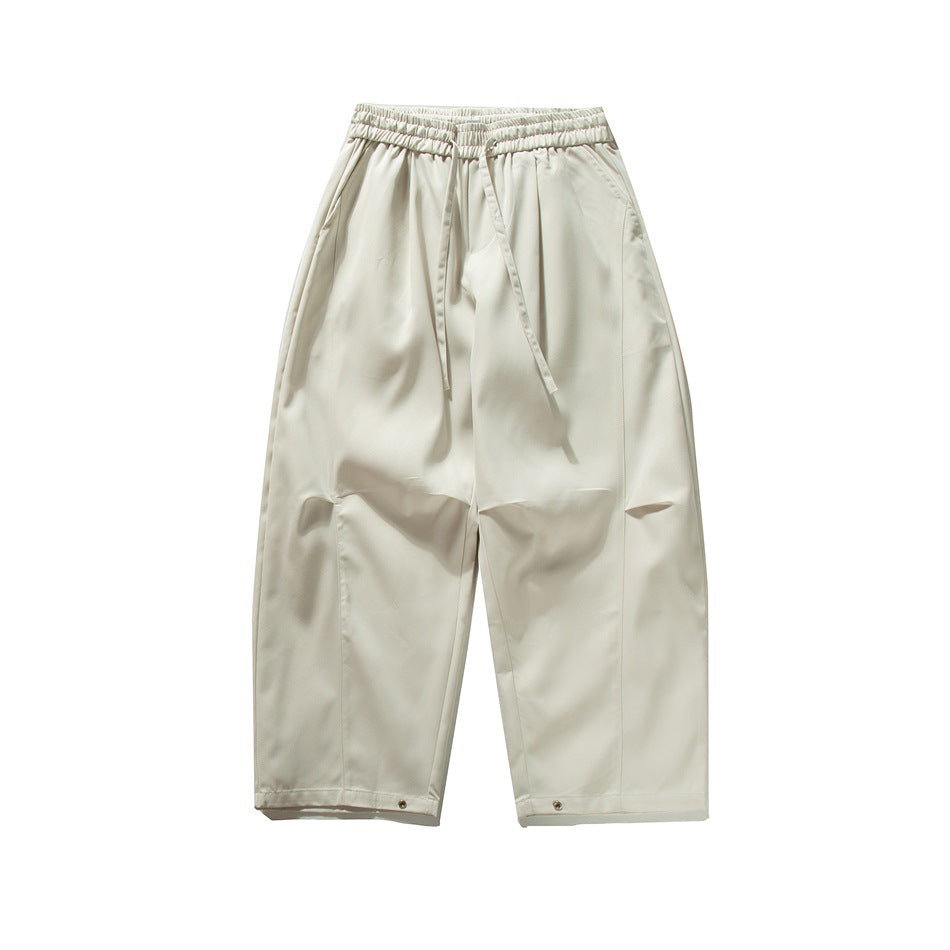 Off-white wide-leg drawstring pants, flat front view with knee folds and hem snaps