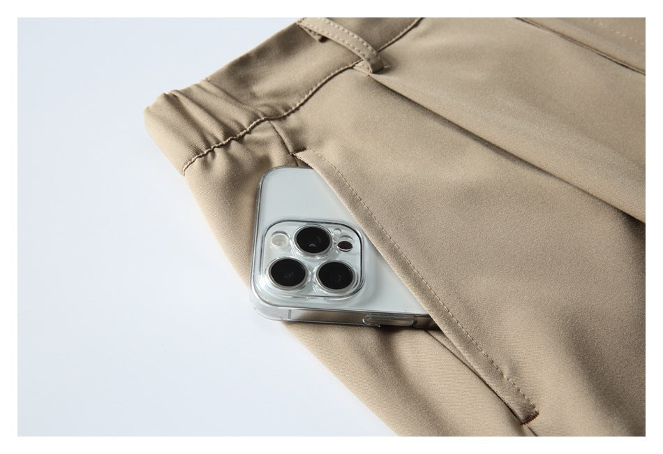 Close-up of a beige trouser side pocket with a smartphone partly tucked inside.