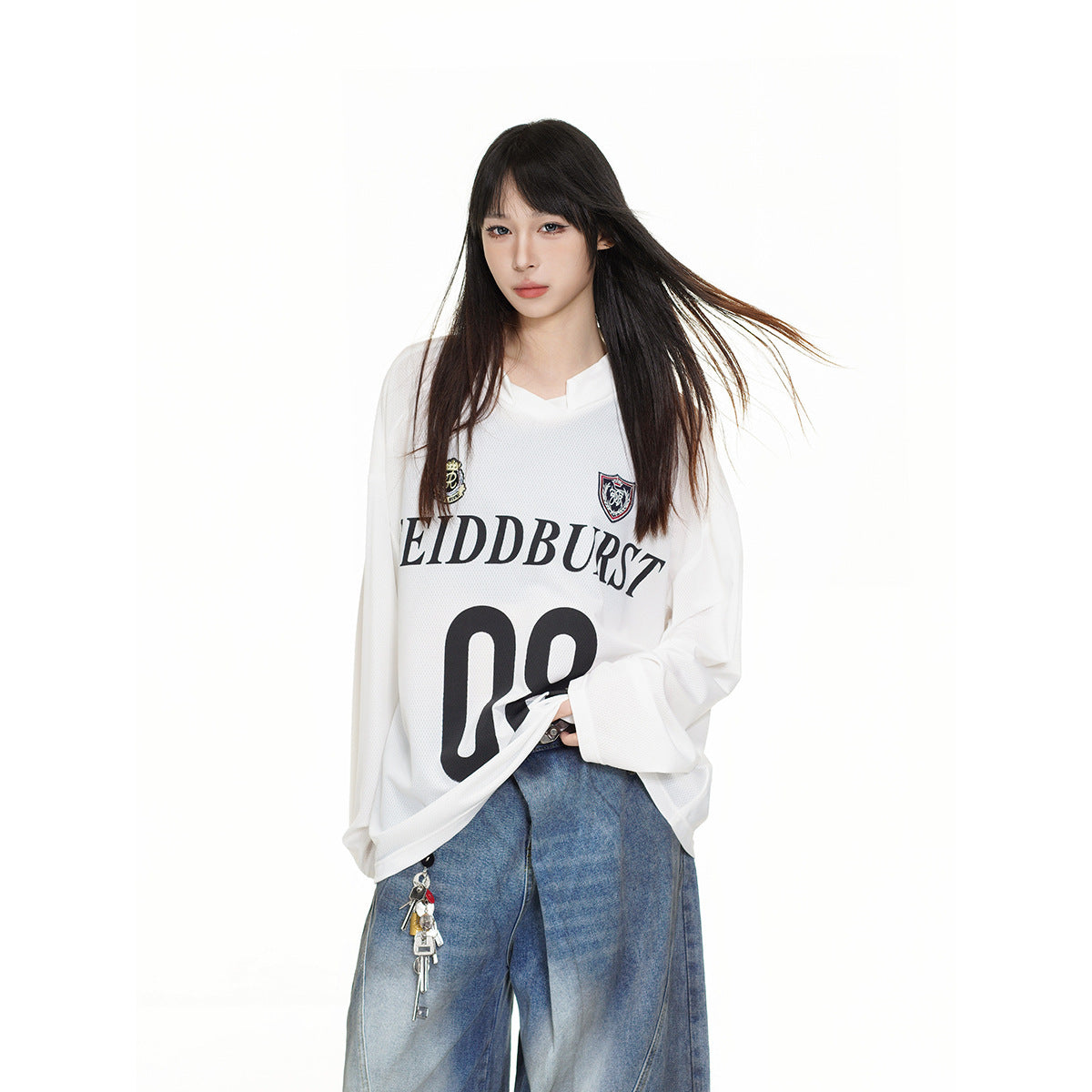 Model wearing an oversized white long-sleeve jersey with crest patches, black lettering and number 08.