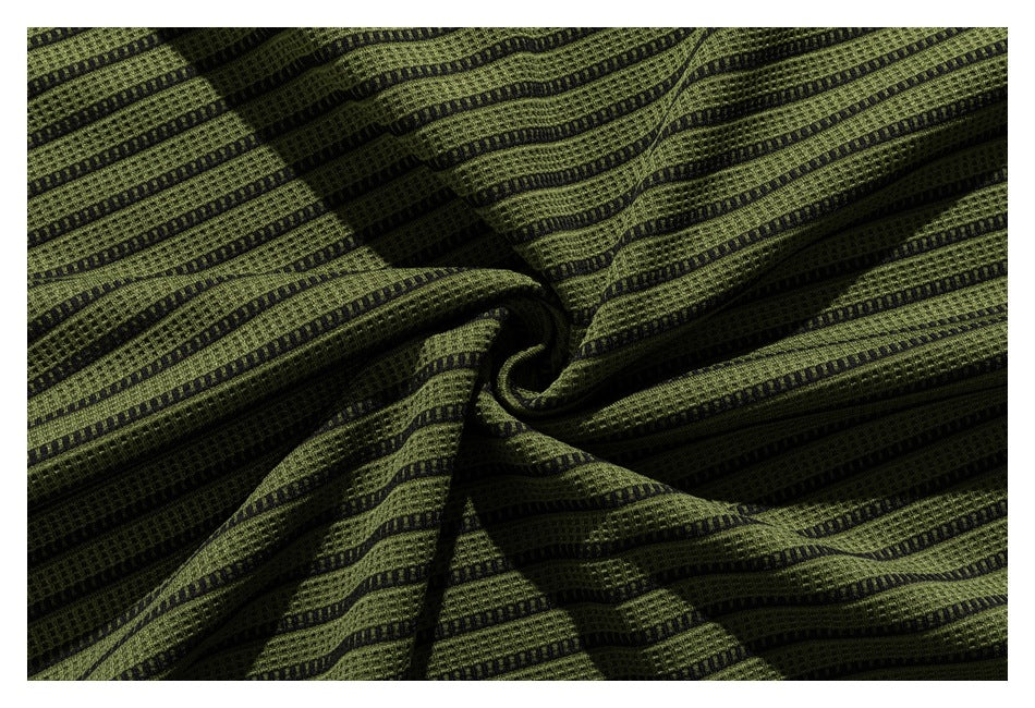 Close-up of olive green and black striped textured fabric gathered into folds.
