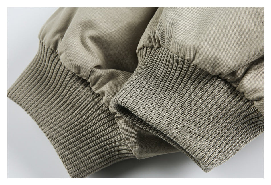 Close-up of ribbed gray-beige cuffs gathered at the ends of light khaki sleeves.