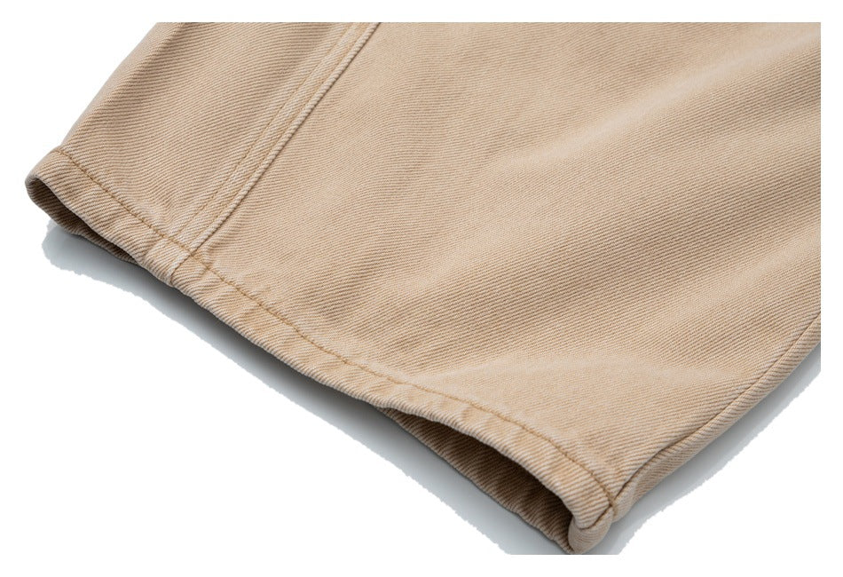 Close-up of beige denim trouser leg hem with double-row stitching and a folded edge.