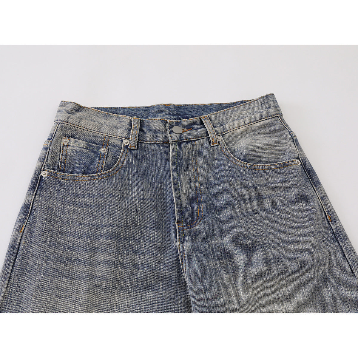 Close-up front view of washed blue-gray jeans showing the waistband, button, belt loops, and front pockets.