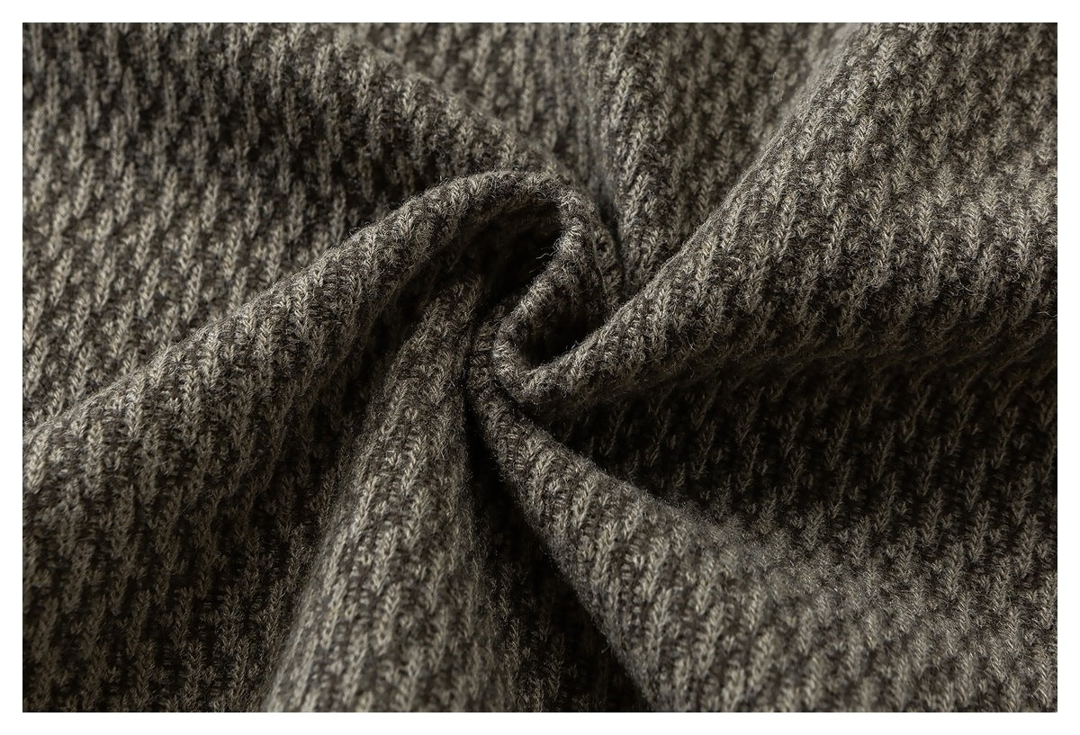 Close-up of gray-brown textured fabric gathered into soft folds.
