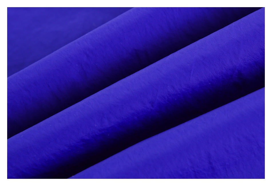 Close-up of royal blue fabric arranged in soft diagonal folds.
