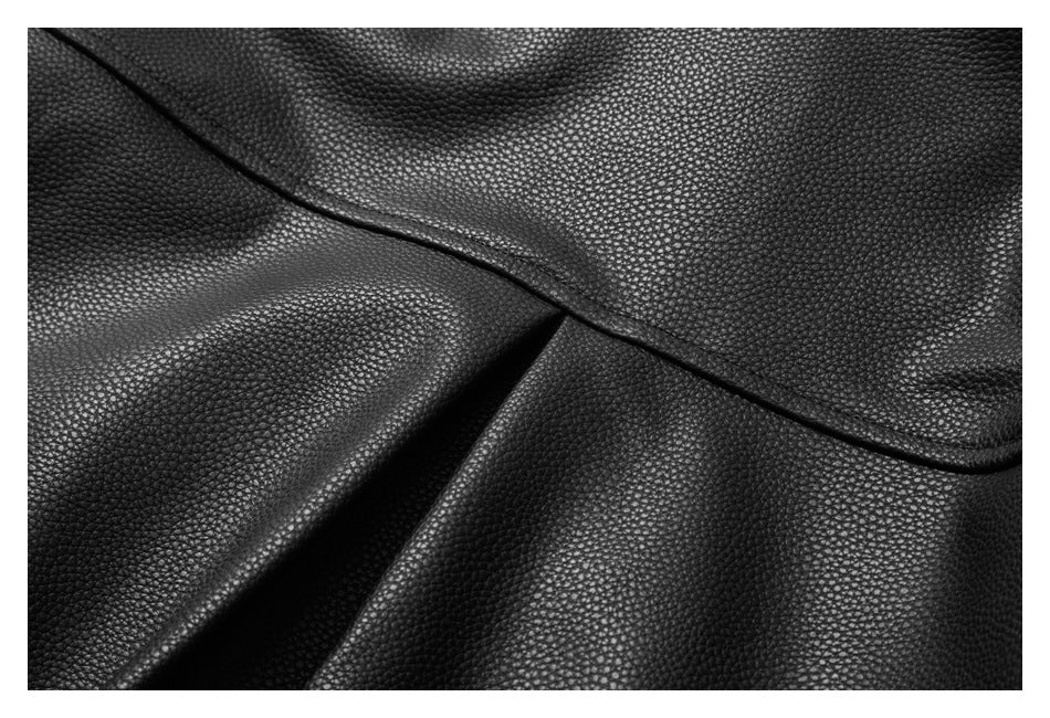 Close-up of the black jacket's pebbled surface, curved seam and folded panel edge.