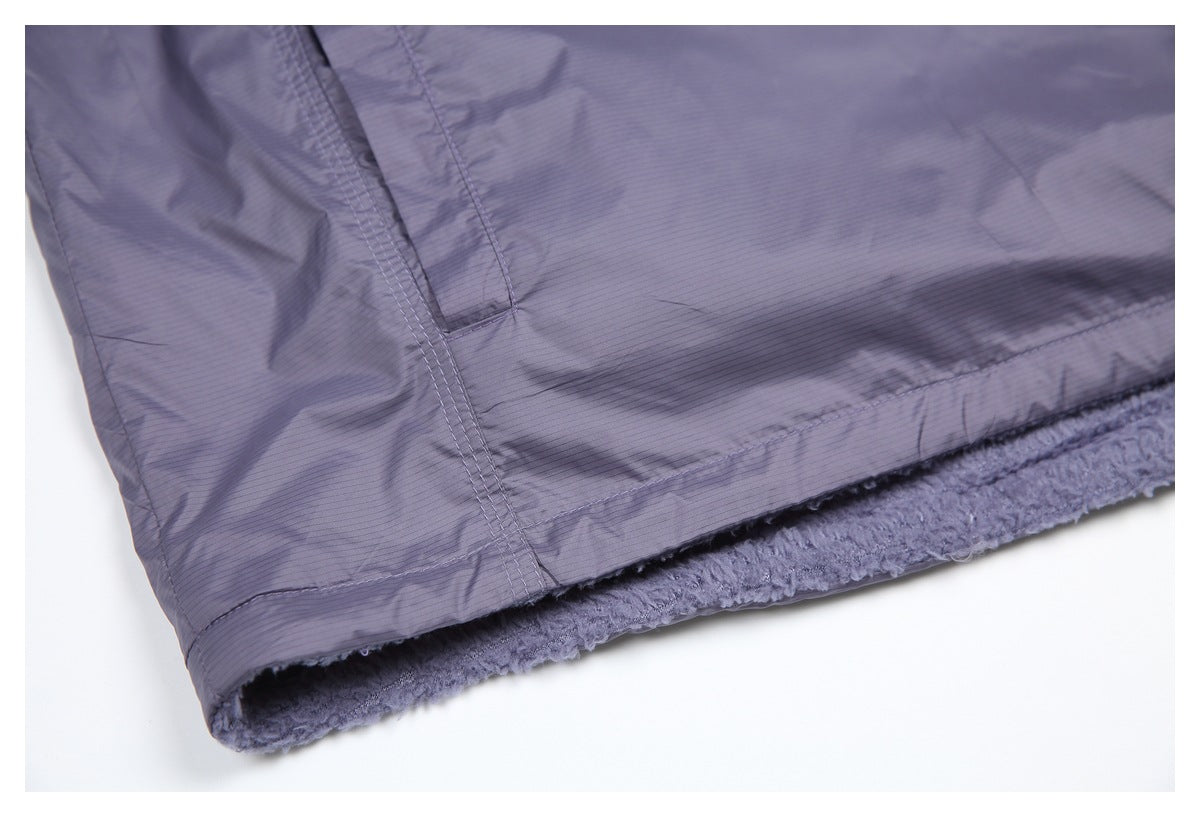 Close-up of the vest's stitched hem and fuzzy lining visible beneath the smooth outer shell.