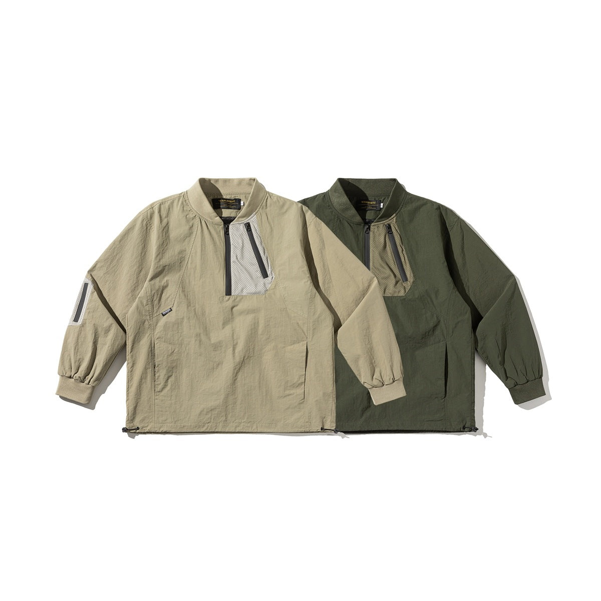 Front view of two pullover jackets, one khaki and one dark olive, with stand collars, zip pockets, mesh panels and elastic