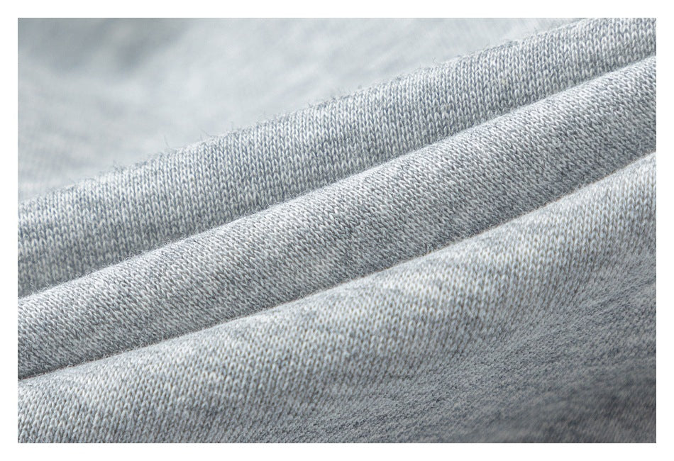 Close-up of light gray knit fabric arranged in soft folds.