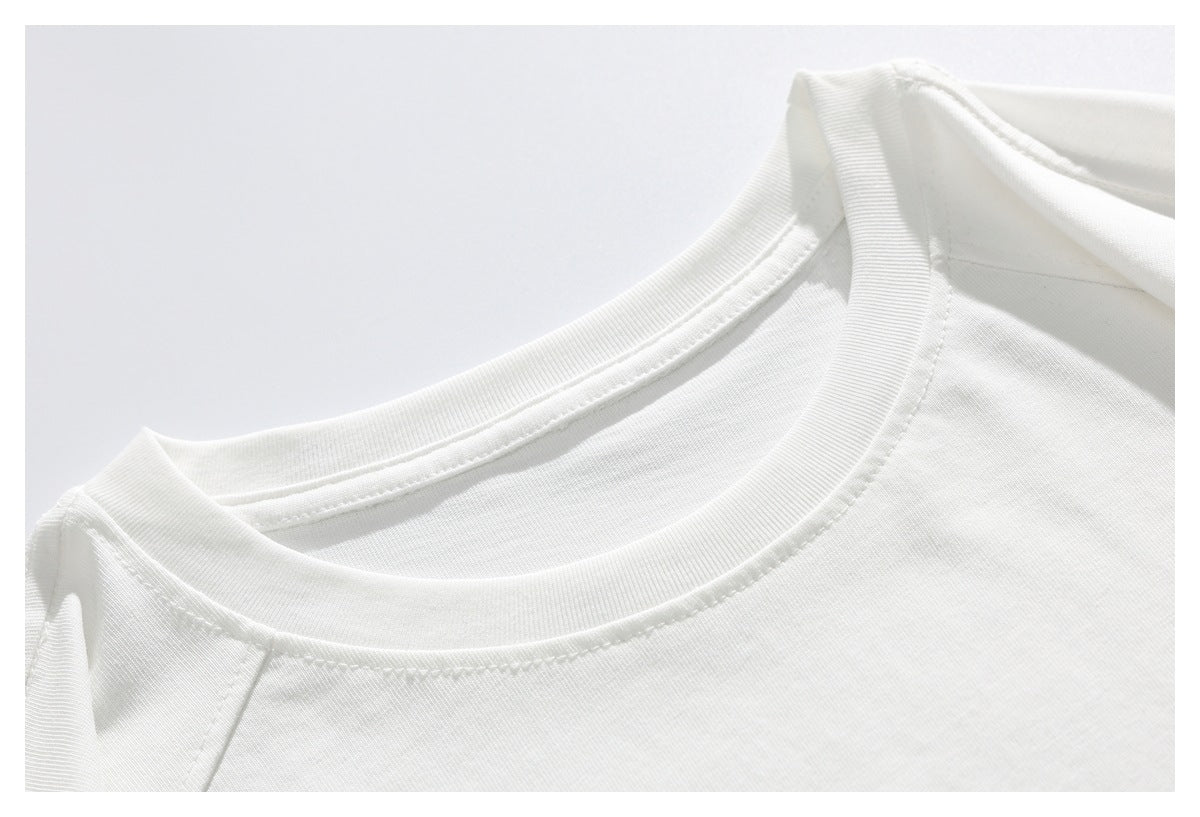 Close-up of a white T-shirt's ribbed crew neckline and shoulder seam.