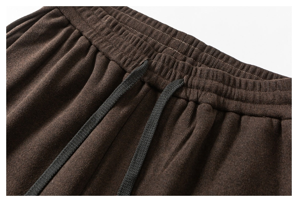Close-up of dark brown pants with a gathered elastic waistband and black drawstrings.
