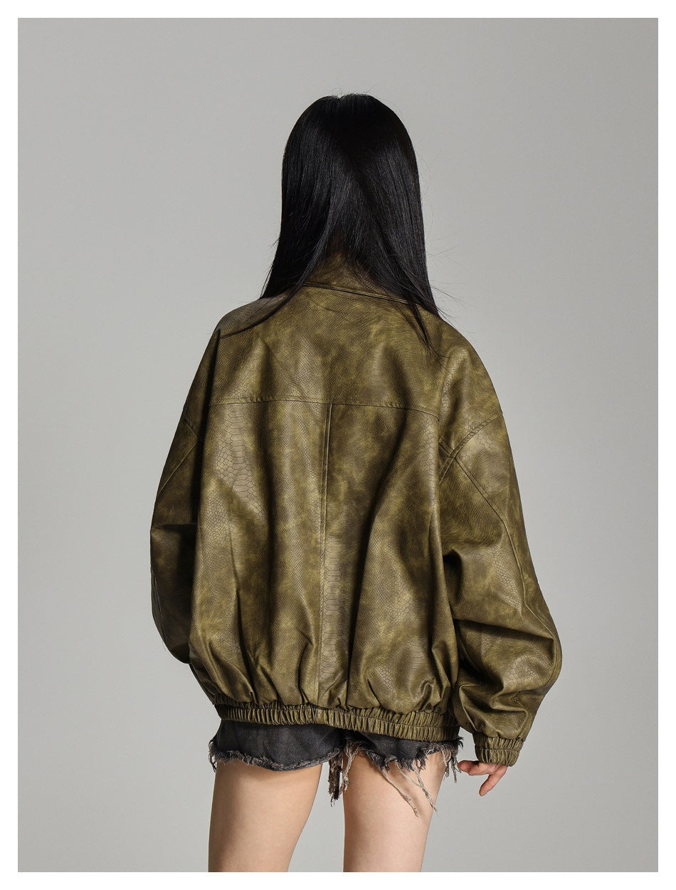 Rear view of a model wearing an oversized olive-brown textured jacket with gathered cuffs and hem.