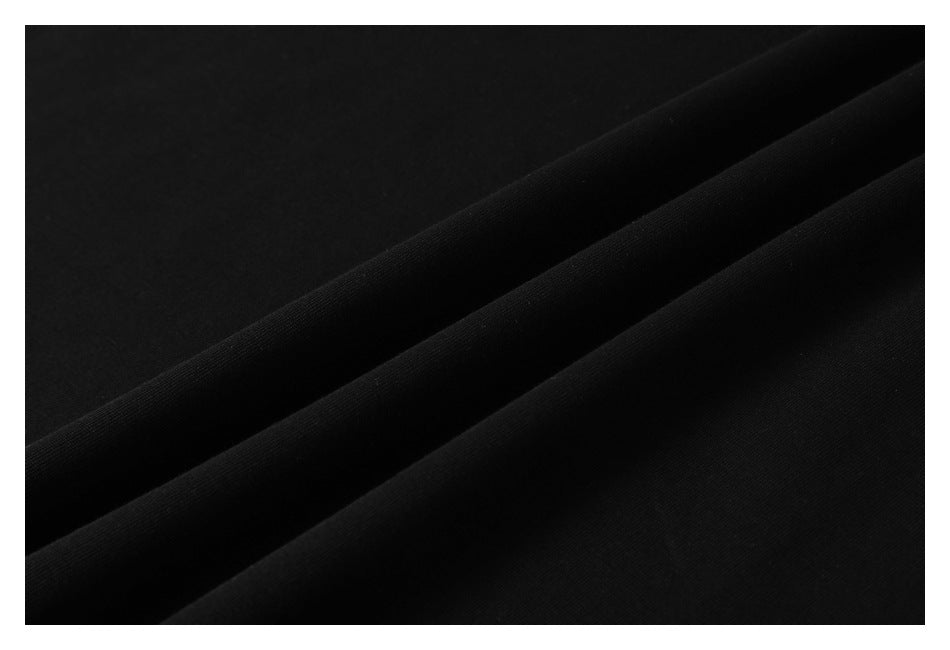 Close-up of smooth black fabric draped into soft folds.