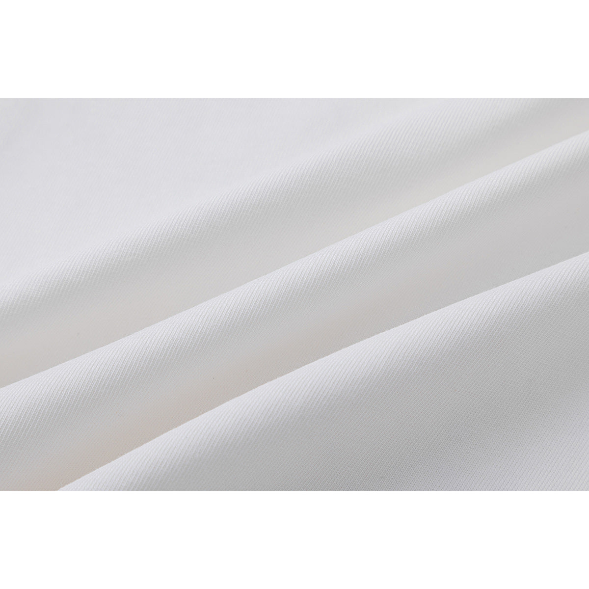 Close-up showing the fine surface texture and folds of white T-shirt fabric.